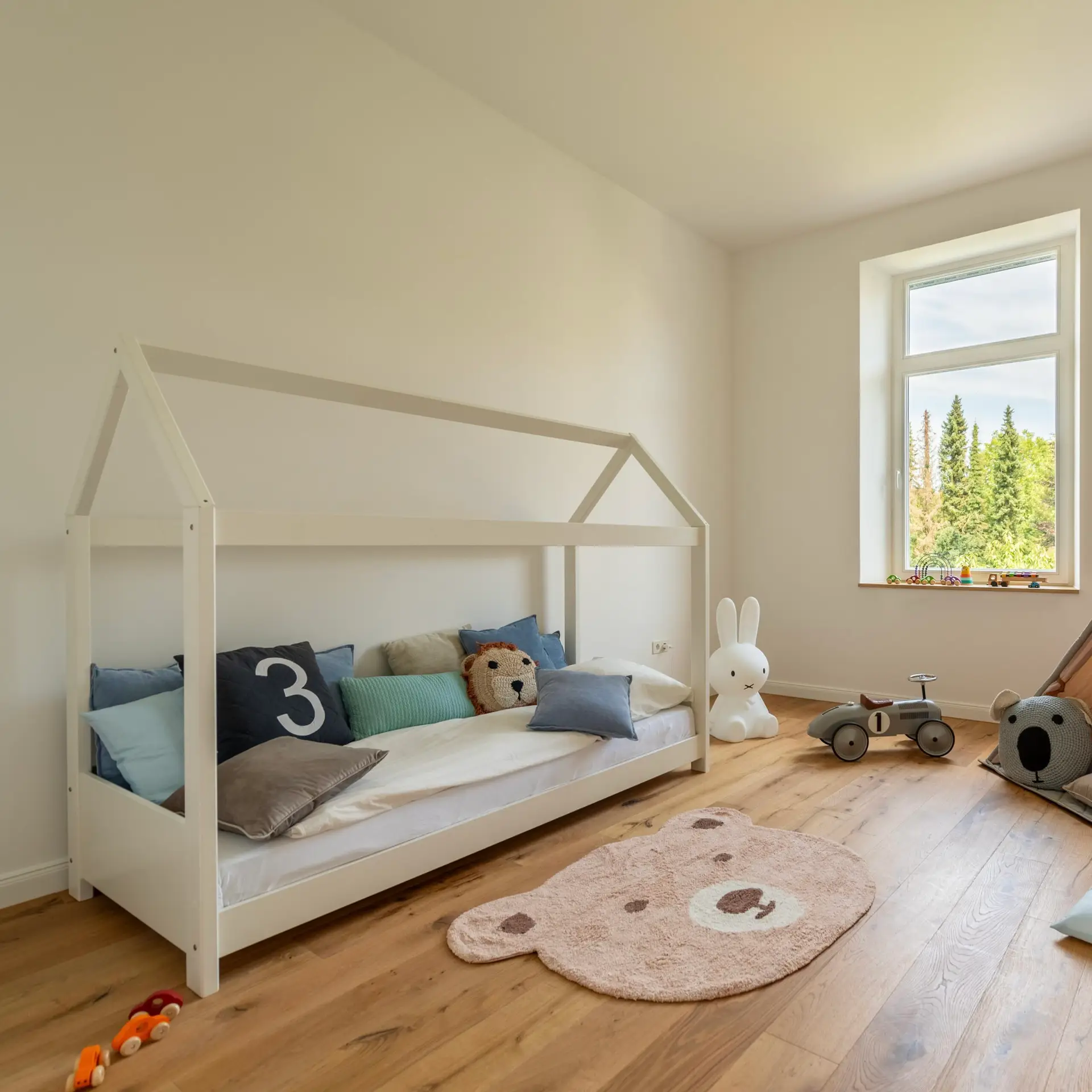 Helles Kinderzimmer mit Spielzeug, Tipi-Zelt und Hausbett als Beispiel für Home Staging